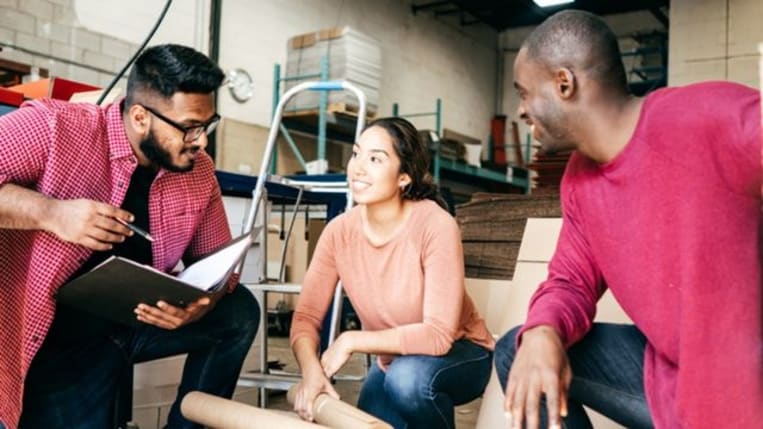 Small business owners in a warehouse talking about a new loan application