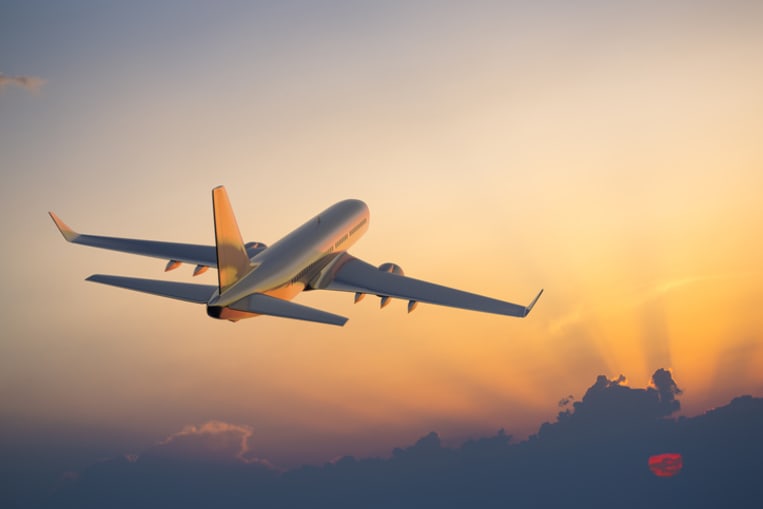 airplane flying in a sunset sky