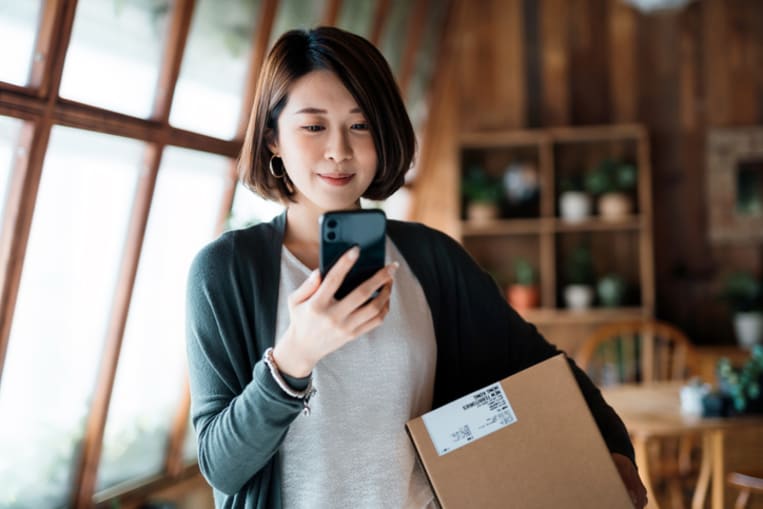 woman holding and looking at cell phone