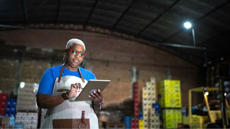 Mature employee using digital tablet at warehouse