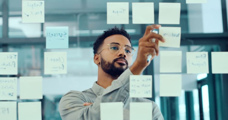 sticky notes on glass man working in office