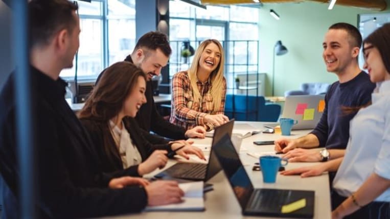 Happy colleagues laughing in the office meeting