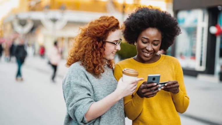 Two women shopping on their phone