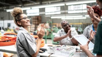 Factory employees celebrating positive news during the workday.