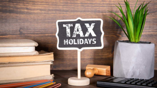 Tax holidays chalkboard with books and colored pencils on a desk