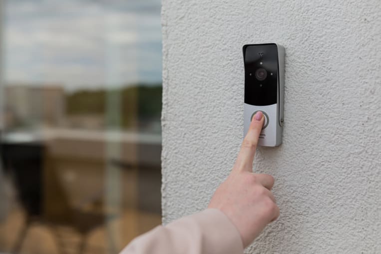 person pressing video doorbell