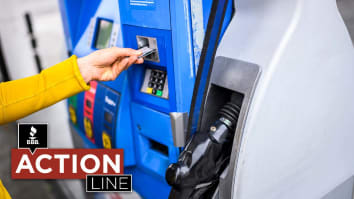 Woman inserting credit card into gas pump