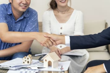 Close up, Man shaking hands represent sale, Asian couple meeting financial adviser for home, real estate purchase, success business contract deals with sale. Success deals. 