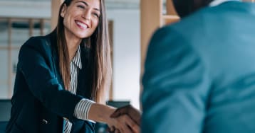 Woman shaking man's hand at meeting