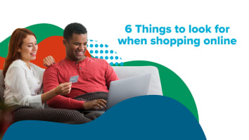 Couple sitting on couch online shopping with credit card and laptop