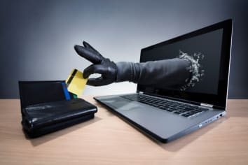 Stealing a credit card through a laptop concept for computer hacker, network security and electronic banking security.