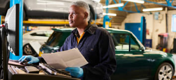 female auto mechanic working on computer in shop