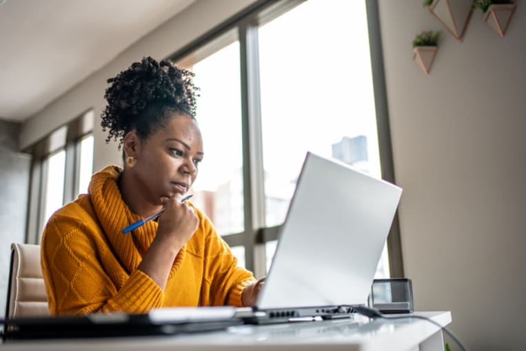 Woman looking questionably at her laptop