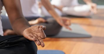 Three people sitting crossed leg with hands in yoga pose