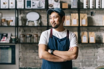 Confident Japanese owner standing at his coffee roastery