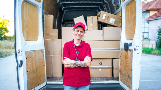 Van with packages and employee in red shirt standing in front of the open rear doors
