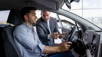 Man teaching another man how to drive