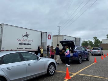 Volunteers unloading documents from a vehicle to be shred on-site.