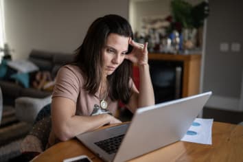 Anxious woman working on laptop