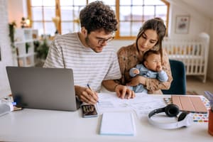 young family with cute little baby going over finances at home