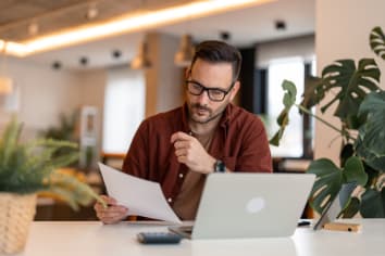 Man sitting by a desk reading data