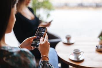 Woman scrolling on phone looking at videos.