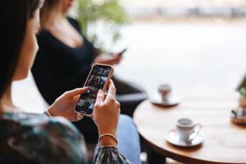 Woman scrolling on phone looking at videos.