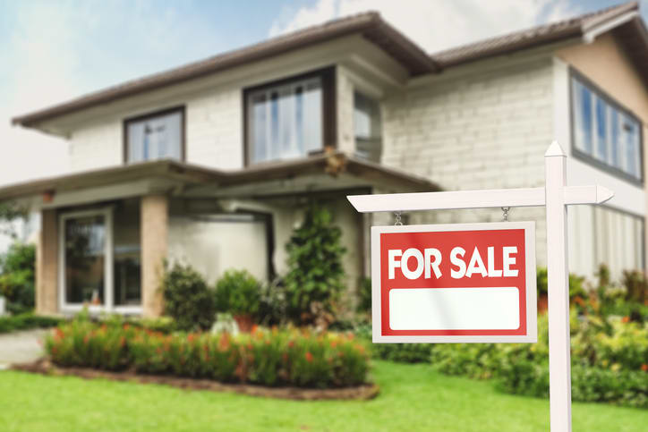 Real Estate Sign in Front of a House with a Garden for Sale - stock photo
