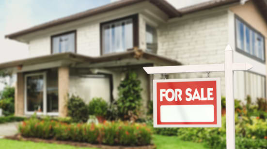 Real Estate Sign in Front of a House with a Garden for Sale - stock photo
