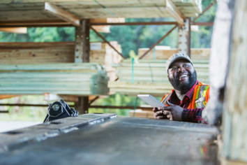 Worker standing by truck loaded with building material