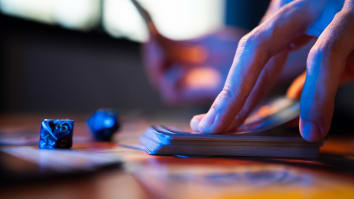 Close up on a hand drawing a trading card from the top of a stack.