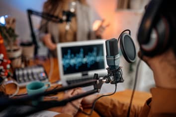 Young people recording podcast in studio.