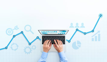 Web analytics and digital marketing. Top view of business man using laptop. Blue graphs and icons.
