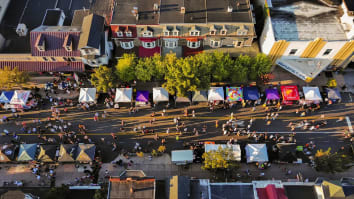Top-down view of vendor tents and attendees at a street festival.