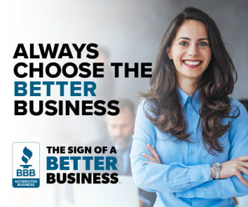 smiling woman in blue button up shirt standing in blurred office scene