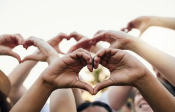 Cropped shot of a group of unrecognizable people forming a hearts with their hands	
