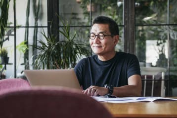 man smiling working on computer