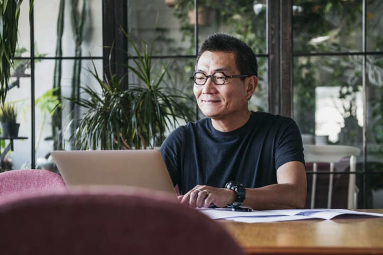 man smiling working on computer