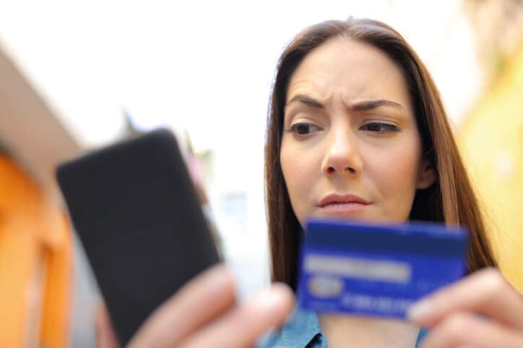woman looking at credit card with a confused look