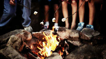 children gathered around a fire for summer camp