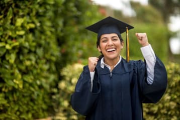 happy graduate celebrating in cap and gown