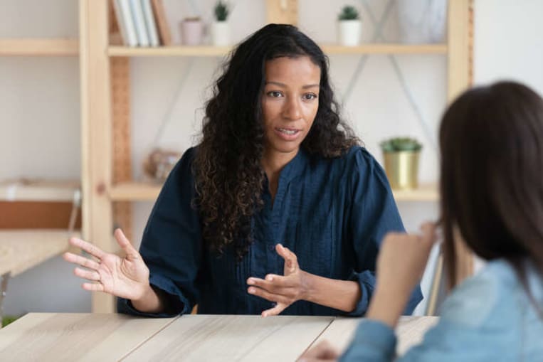 african american woman advising young woman in office