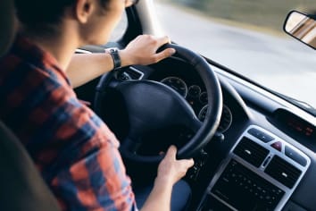 woman in plaid shirt driving in car