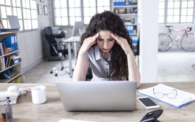 woman with a worried look sitting at the computer