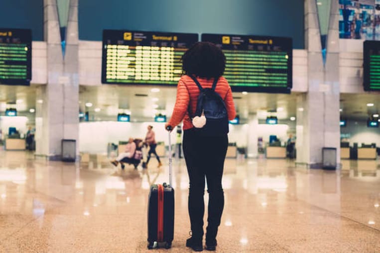 person walking through airport with bag