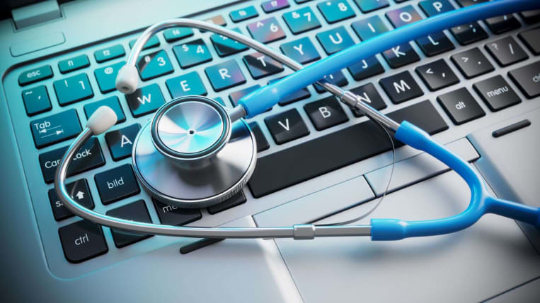 doctor's stethoscope sitting on computer keypad