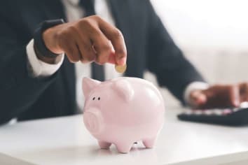 businessman saving money in piggy bank