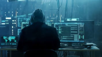 shady hooded figure above laptop