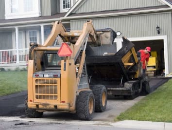 home with asphalt truck machine in driveway