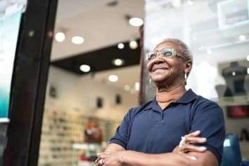 older african american woman smiling in front of store
